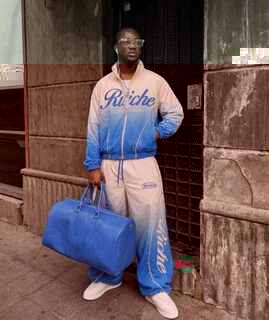 Male model wearing a custom manufactured orange and white ombre tracksuit with branded print